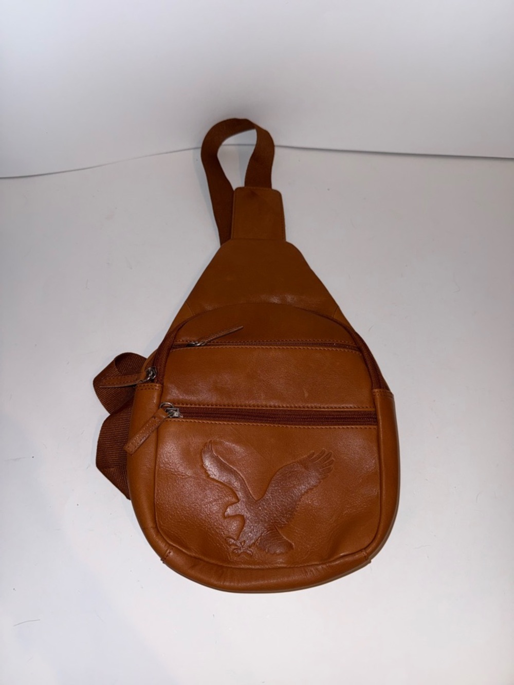 American Eagle Outfitters Tan Leather Sling Bag with Embossed Eagle